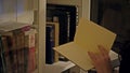 Woman pulls a book off the bookshelf