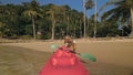 Woman pulls canoe with paddle to azure sea water from beach Royalty Free Stock Photo