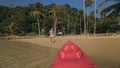 Woman pulls canoe with paddle to azure sea water from beach Royalty Free Stock Photo