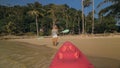 Woman pulls canoe with paddle to azure sea water from beach Royalty Free Stock Photo