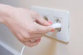 The woman pulls the electrical plug out of the socket wire