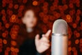 Woman pulls hand to microphone for sing at concert. Royalty Free Stock Photo
