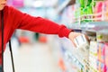 A woman pulls a pack of sanitary pads from the shelf. Hand close-up. The concept of buying personal care products Royalty Free Stock Photo