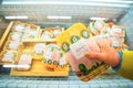 A woman pulls packaged chicken meat from a freezer at