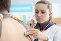 Woman pulmonologist listening to lungs of patient with stethoscope in clinic Royalty Free Stock Photo