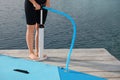 Woman pumping up SUP board on pier, closeup Royalty Free Stock Photo