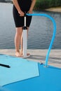 Woman pumping up SUP board on pier, closeup Royalty Free Stock Photo