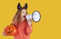 Woman with pumpkin and megaphone making announcement about Halloween event or holiday sale