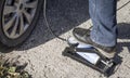 A woman pumps air into the wheels using a car foot pump Royalty Free Stock Photo