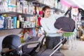 Woman purchaser choosing bag for baby carriage