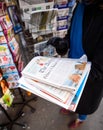 Woman purchases aThe Daily Telegraph newspaper from a newsstand