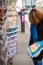 Woman purchases a Charlie Hebdo, Le Monde newspaper from a newsstand