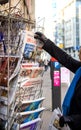 Woman purchases L`Alsace French newspaper from a newsstand