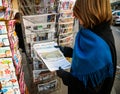 Woman purchases The Times newspaper from a newsstand with Donald