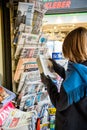 Woman purchases a Wall Street Journal newspaper from a newsstand