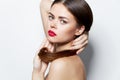 Woman Pure skin red lips attractive look holding on to hair bright makeup