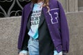 Woman with purple baseball jacket before Angelo Marani fashion show, Milan Fashion Week street style on