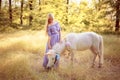 Woman in purple dress hugging white unicorn horse. Dreams come t Royalty Free Stock Photo