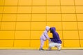 Woman in purple hoody have fun with cute girl 4-5 years old. Mommy and little daughter on yellow mall wall Royalty Free Stock Photo