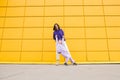 Woman in purple hoody have fun with cute girl 4-5 years old. Mommy and little daughter on yellow mall wall Royalty Free Stock Photo