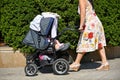 Woman pushes a baby carriage on the city street