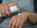 Woman pushes cream from the bottle on the back of her hand