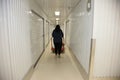 Woman pushes a metal trolley with belongings down to a self storage locker unit Royalty Free Stock Photo