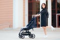 Woman Pushing Baby Stroller Jumping with Joy Royalty Free Stock Photo