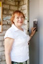 Woman pushing button of house intercom Royalty Free Stock Photo