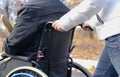 Woman pushing a disabled man in a wheelchair Royalty Free Stock Photo