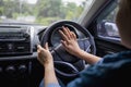 Woman pushing horn while driving sitting of a steering wheel press car, honking sound to warn other people in traffic concept Royalty Free Stock Photo