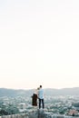 Woman put her head on the man shoulder on a stone wall overlooking the mountains. Back view Royalty Free Stock Photo
