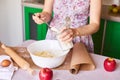 Woman put ingredients for apple pie into big white bowl. Preparing dough in the kitchen Royalty Free Stock Photo
