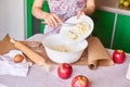 Woman put ingredients for apple pie into big white bowl. Preparing dough in the kitchen Royalty Free Stock Photo