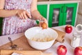 Woman put ingredients for apple pie into big white bowl. Preparing dough in the kitchen Royalty Free Stock Photo