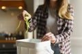 Woman put organic food waste in a compost container. Female person recycling compostable leftovers in a bokashi bin at home