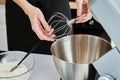 Woman put in whisk nozzle in electric mixer