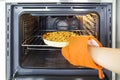 Woman puts apple pie inside oven Royalty Free Stock Photo