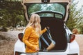 Woman puts backpack in a car trunk road trop vacations travel active lifestyle outdoor