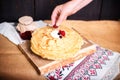 Woman puts berries on pancakes with cream, hands closeup, home cooking.