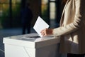 A woman puts a bill into the ballot box at the polling station