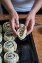 A woman puts buns of buns on a baking tray Royalty Free Stock Photo