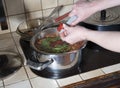 a woman puts a cherry tomato in a pan, ingredients for cooking borsch soup