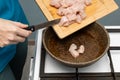 woman puts chicken pieces on a frying pan Royalty Free Stock Photo