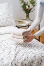 Woman puts clean fresh towels on the bed in hotel room Royalty Free Stock Photo