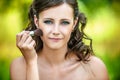 Woman puts on face powder brush Royalty Free Stock Photo