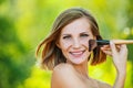 Woman puts on face powder brush Royalty Free Stock Photo