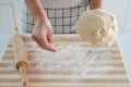 Woman puts flour on wooden table and holds dough in her hand. Increasing price of wheat, flour and bread. Homemade bread Royalty Free Stock Photo