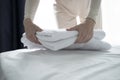 Woman puts fresh clean towels on the bed in a hotel room for guests, close-up. A woman& x27;s hand touches soft terry Royalty Free Stock Photo