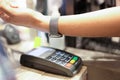 Woman puts hand with smart watch and pays contactless payment